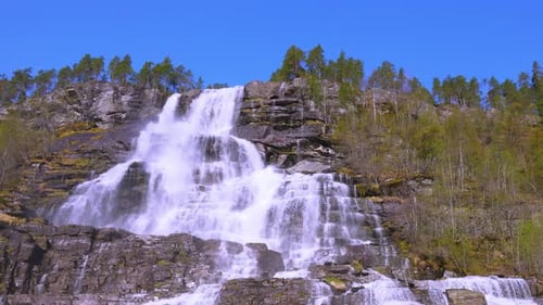 The spectacular Tvindfossen waterfall is located in sunny Voss, Norway.