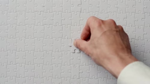 Hand Putting Last Puzzle Piece Finishing Closeup White Jigsaw Being Assembled