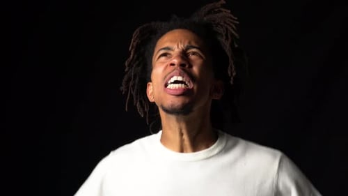Frustrated Man Yelling Expressing Strong Emotion Against Black Backdrop