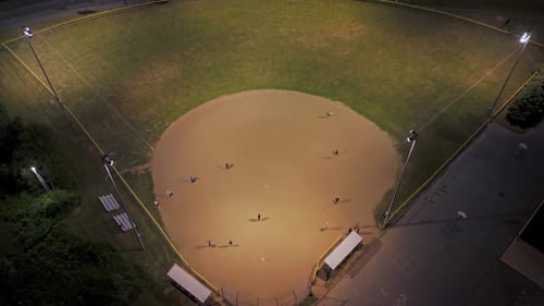 Aerial View of a Baseball Field at Night with Players Playing American Baseball