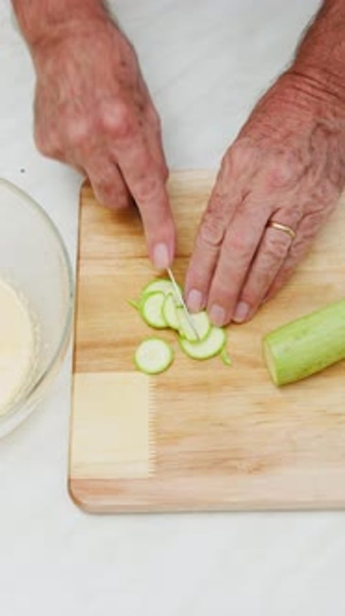 Zucchini Being Sliced on Cutting Board for Cooking