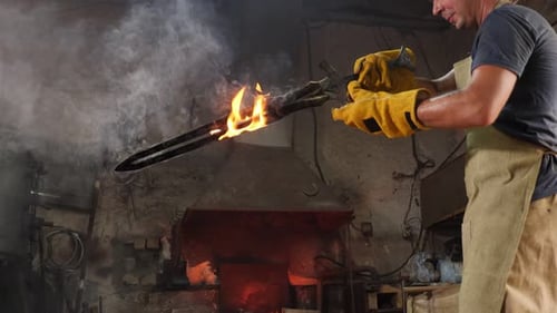 A Blacksmith Forged a Sword in a Forge He Holds a Redhot Sword with Sparks