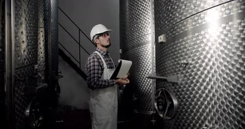 Vigneron à la recherche d'équipements pour la distillation et la fermentation dans une usine de vin