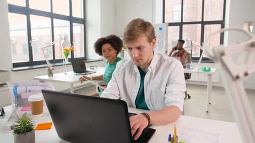 Colleagues Collaborate on Laptop in Bright Modern Office