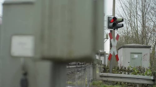 Equipamento de travessia ferroviária embaçado com foco nítido em uma luz de sinalização vermelha
