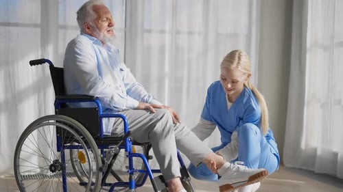 Senior Man in Wheelchair Receiving Foot Care