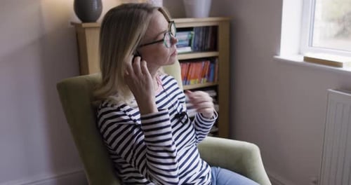 Woman Inserts Earbuds then Uses Smartphone