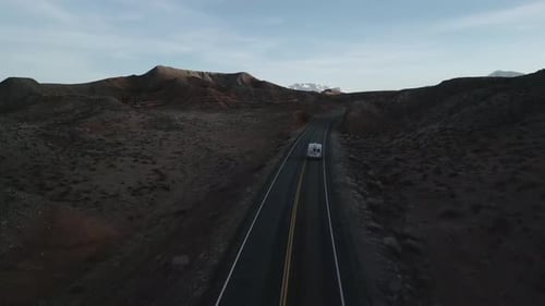 A lone camper truck meanders along the road, navigating the isolated scenery of Utah, USA, the spiri