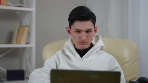 Young Adult Uses Laptop Indoors