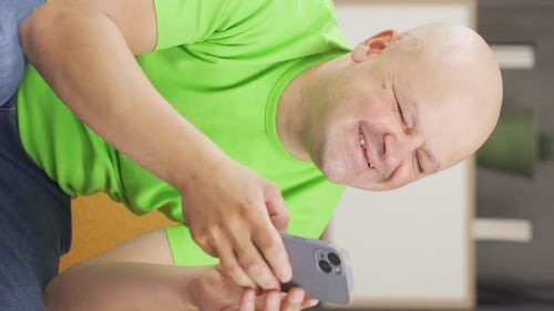 Happy Man Watching Smartphone Indoors