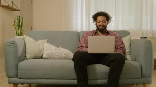 Man Working on Laptop at Home on Couch