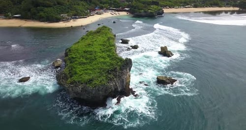 Aerial footage of tropical beach with coral rocks that hit by the wave