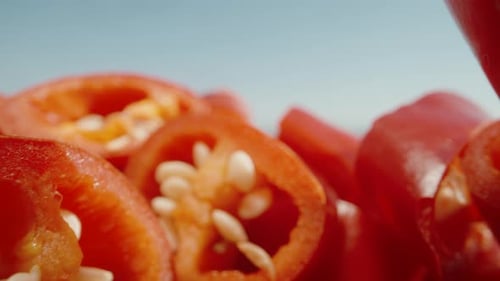 Sliced red pepper, camera slides under the peppers. Dolly slider extreme close-up.