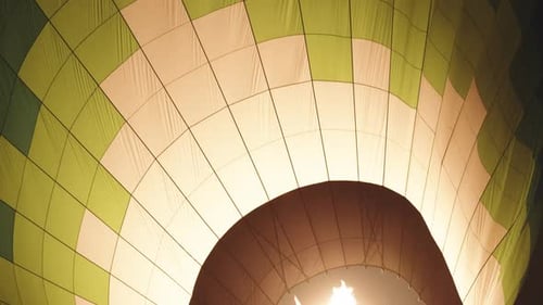 A close-up of a colorful hot air balloon, it's still on the ground and only starting to fill up.