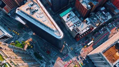 Numerous cars move by the Fifth Avenue near the Flatiron Building. Busy lifestyle of metropolis.