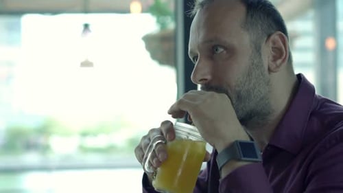 Relaxed Young Man Drinking Cocktail in Cafe
