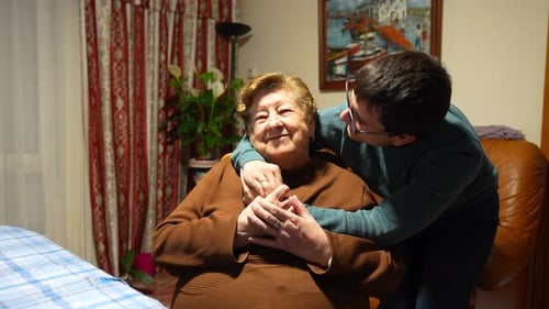 Loving Grandson Hugging His Grandmother at Home