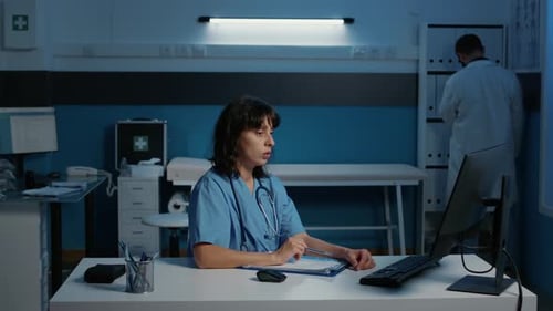 Médico enfermeiro com uniforme azul e estetoscópio analisando relatório de doença do paciente