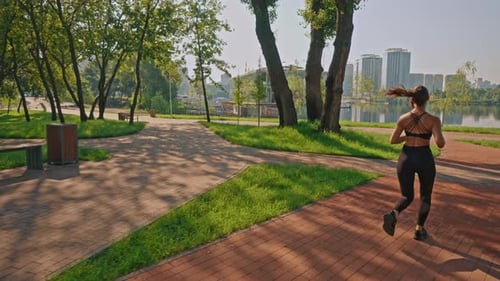 Woman Runs in City Park for Morning Exercise
