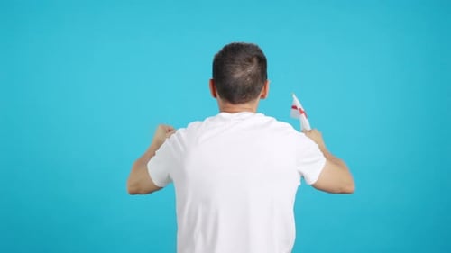 Rear View of a Man Waving a English Pennant
