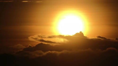 Close up sunrise shot of the sun with fast moving clouds. No people. Telephoto. 4k.