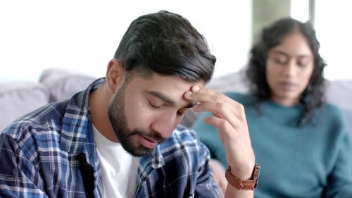 couple sitting on sofa and arguing at home, in slow motion