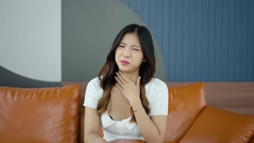 Young Woman Experiencing Sore Throat at Home