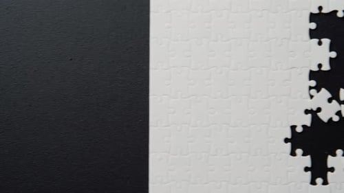White Puzzle Elements Assembled on Black Background Indoor Closeup Top View