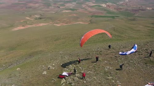 Vue aérienne d'un parapente sautant depuis la colline