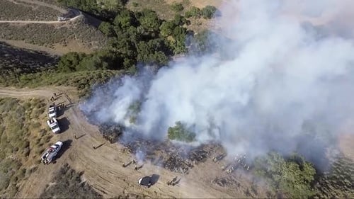 AERIAL - Trainee firefighters control the fire