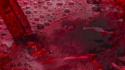 Red liquid bubbles and pours