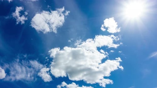 Blue Sky with White Clouds and Sun. Puffy Fluffy White Clouds Moving Fast. Cumulus Cloudscape