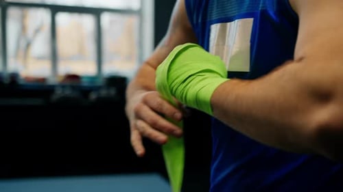 Muscular Boxer Wrapping Hands Getting Ready to Fight