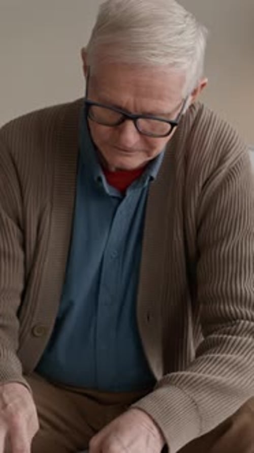 Vertical of Worried Man Checking Overdue Bills and Expenses at Home