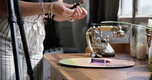 Millennial woman prepares cosmetics for photo shoot in bright studio sunlight