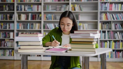 Exhausted Asian Student Puts Head on Hands Nervously