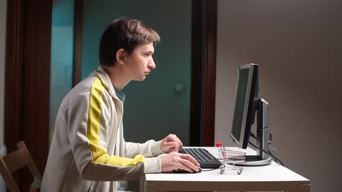 Man Typing on Computer Keyboard at Desk
