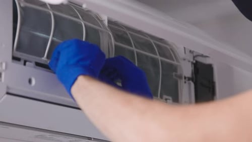 Handyman Does Routine Air Conditioning Maintenance in the Apartments