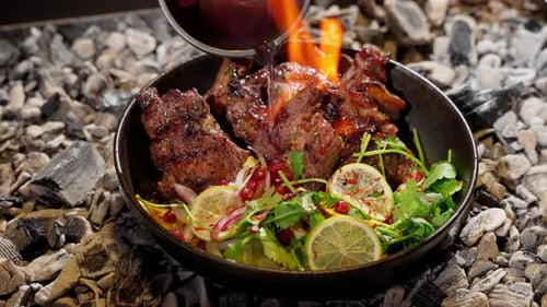 Delicious Meat with Salad Being Flambe on Coals