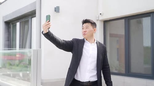 young asian businessman talking on video call online using mobile phone or smartphone camera.