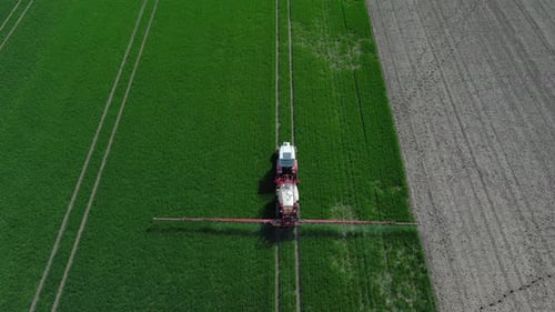 Farming Tractor Crop Sprayer on Green Field