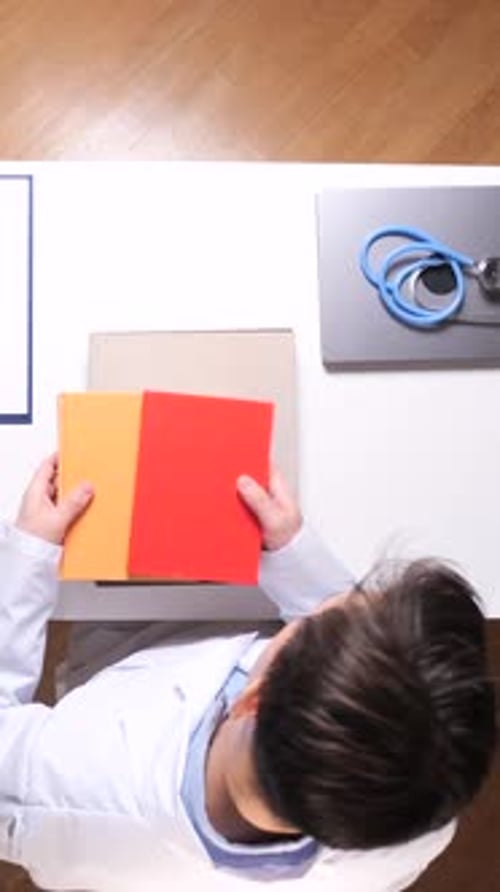 Doctor Reading Medical Books at White Desk