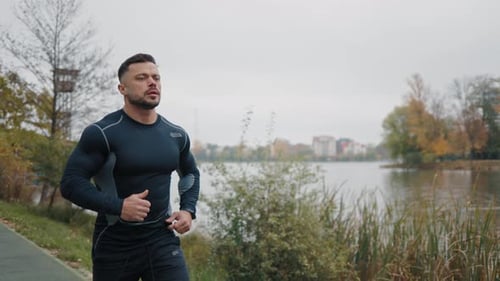 Attractive Man Guy Jogging in the Park on a Background of Trees Caucasian Runner Running Morning Jog