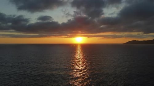 A beautiful, dramatic seascape sunrise over calm water. Stunning cloudscape ocean horizon.