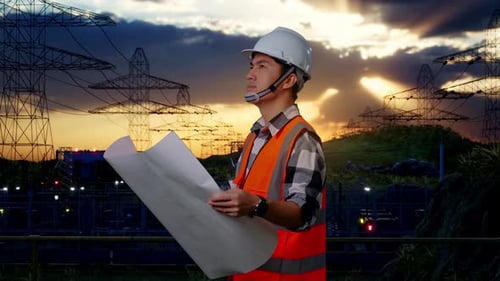 Side View Of Asian Male Engineer Looking At Blueprint In His Hands Near High voltage tower