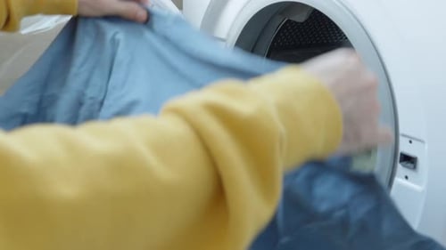 Füllen Sie die WASCHMASCHINE mit schmutzigen Kleidungsstücken