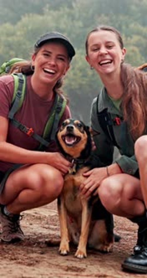 Women with dog smiling outdoors