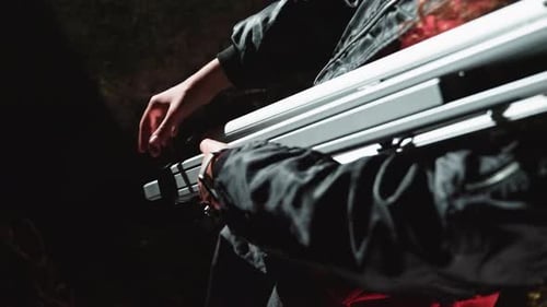 Hands Adjusting Equipment in Dark Setting