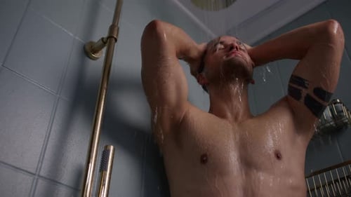 Man Washing Under Shower Head in Bathroom
