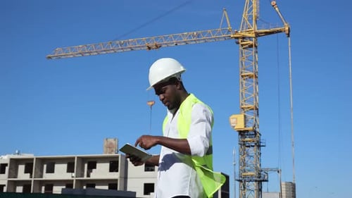 African American Man Types Report About Building at Sunlight
